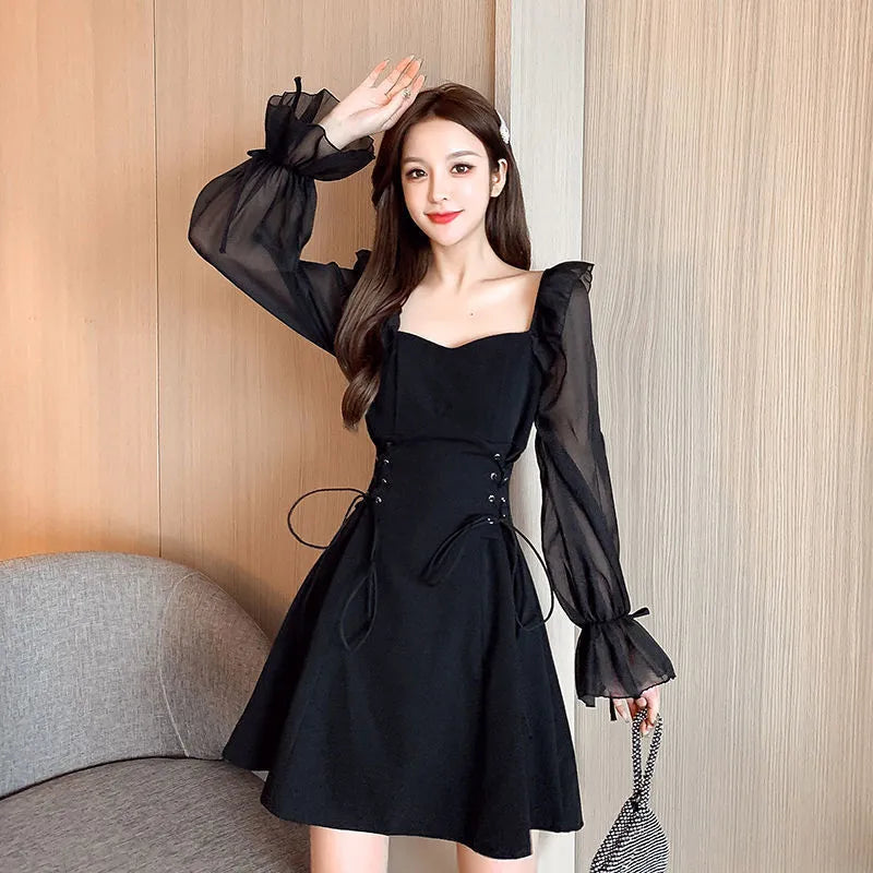 White women's chiffon dress with patchwork detail, long sleeves, and a long slimming skirt.