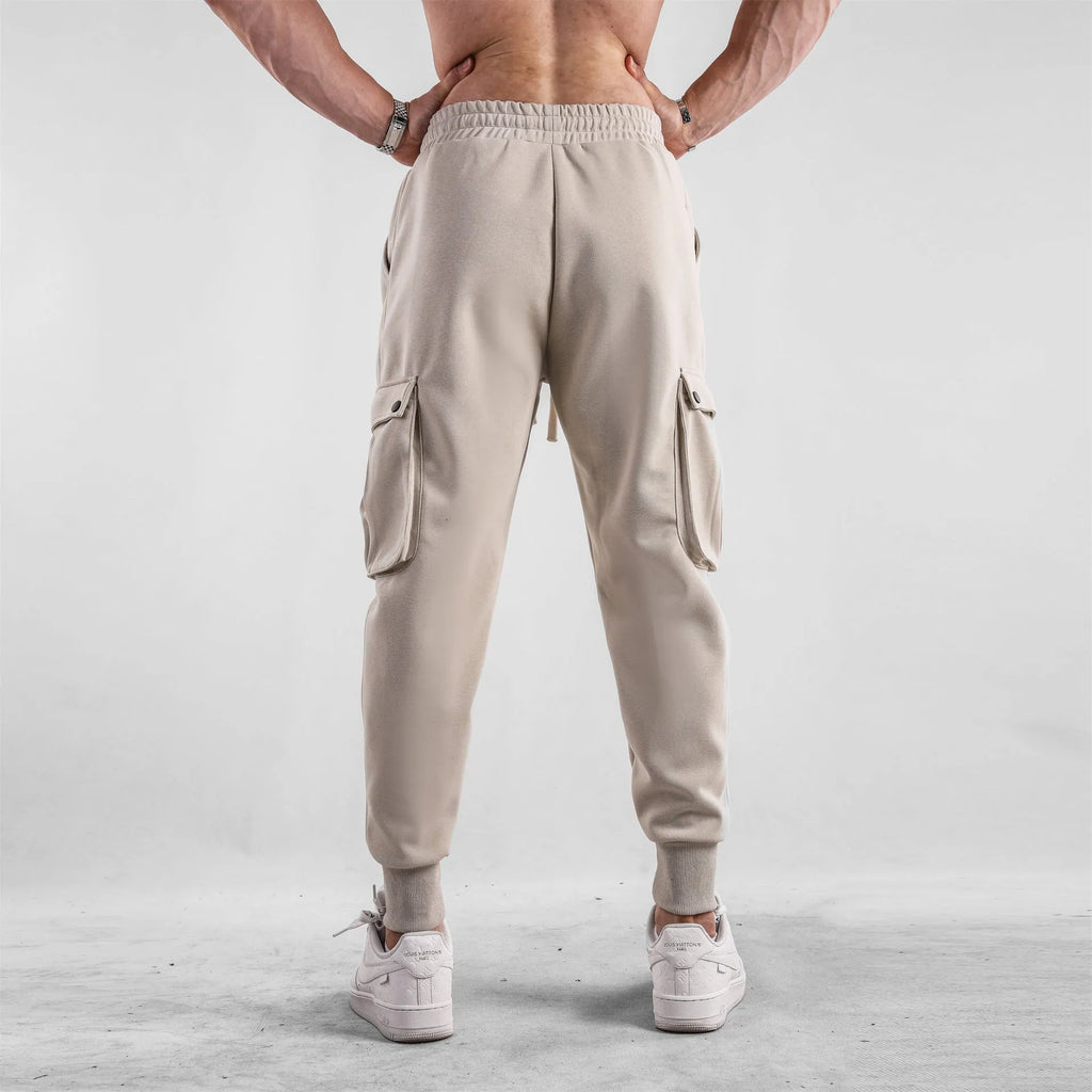 Men's loose fit American sports trousers with ankle ties in apricot colour showing multi-pocket design