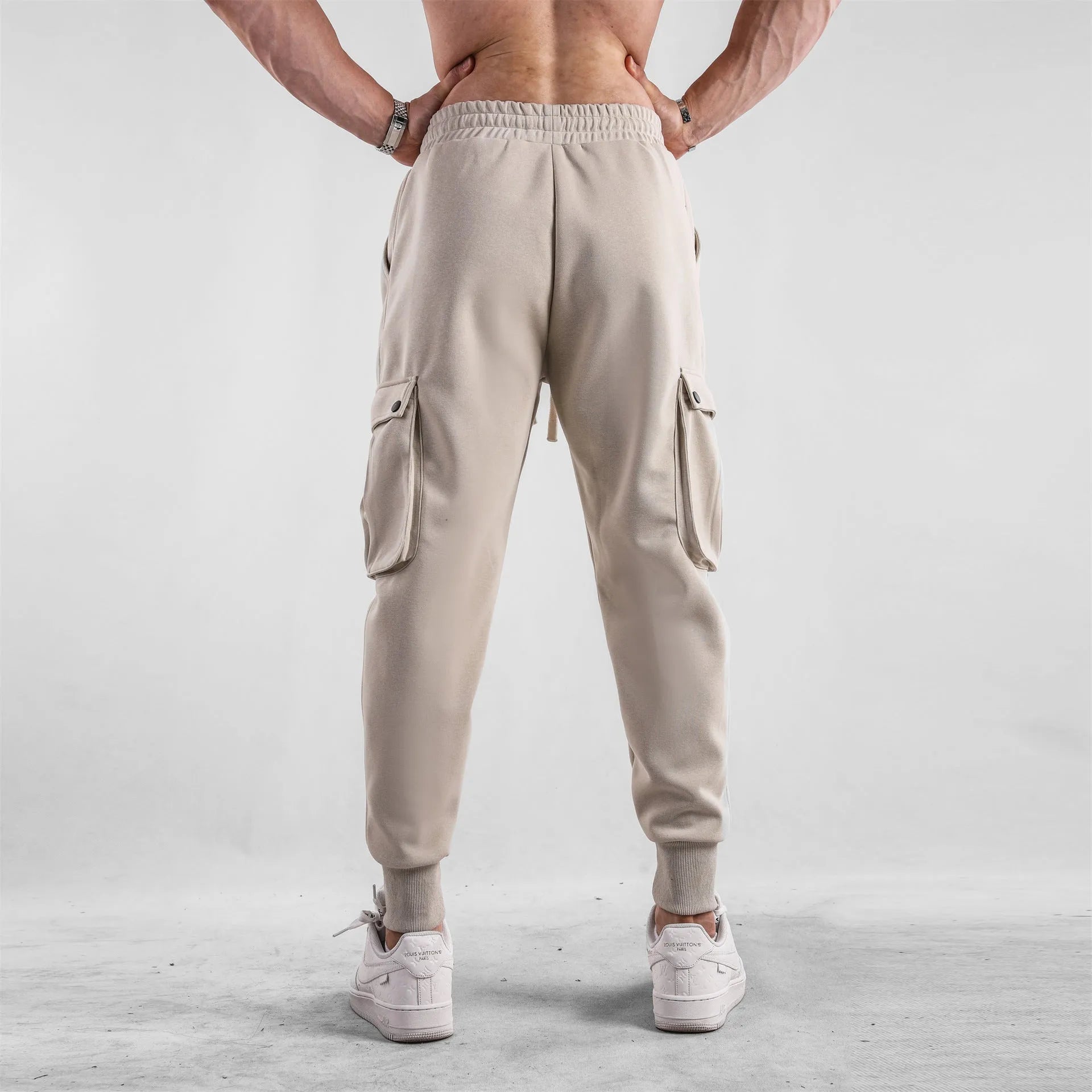 Men's loose fit American sports trousers with ankle ties in apricot colour showing multi-pocket design
