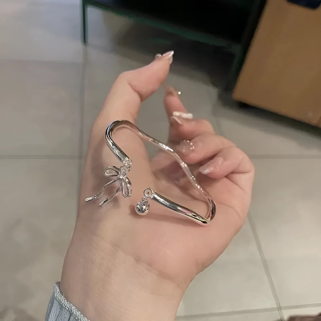 Adjustable silver bracelet with bow design and opening clasp on zinc alloy base