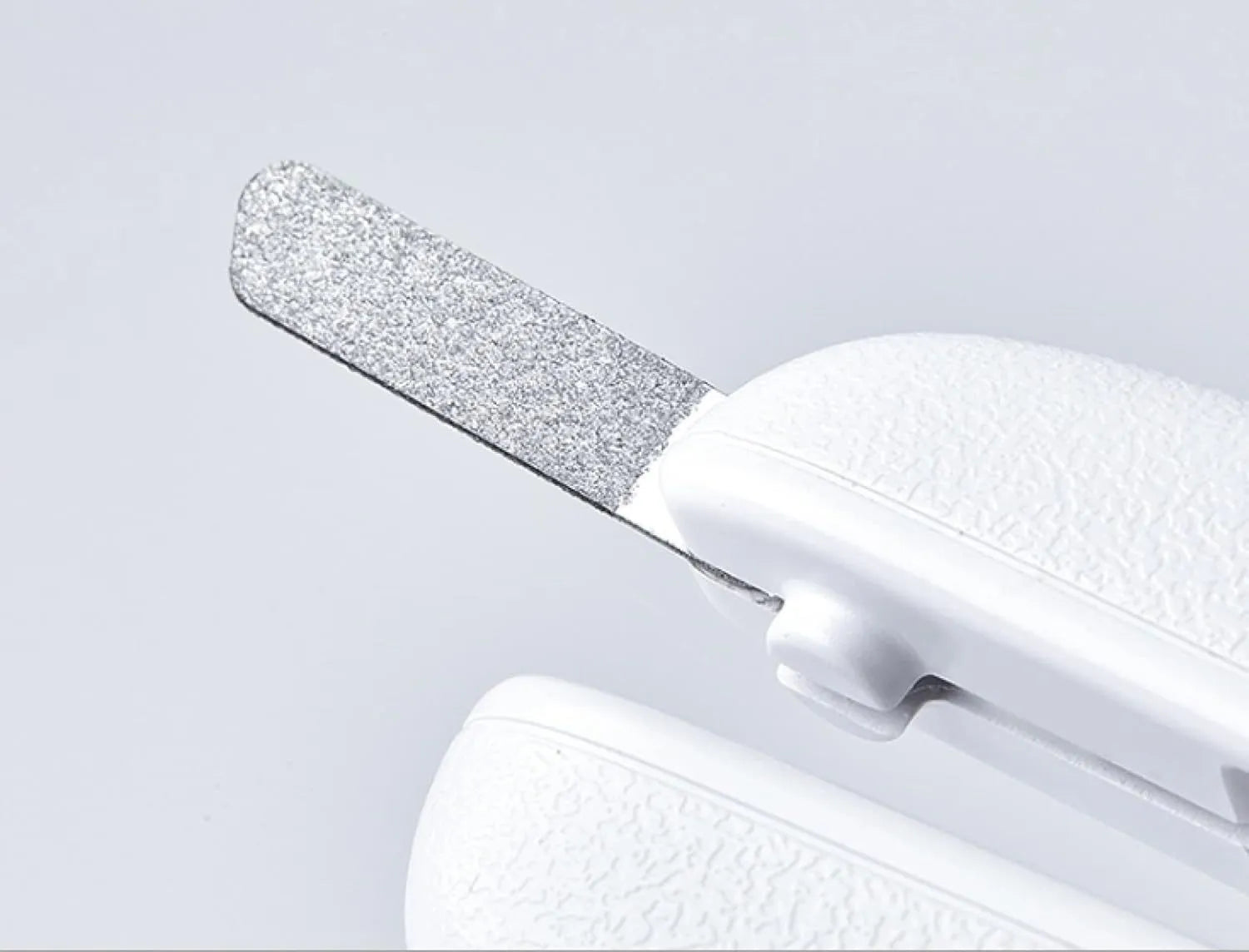 White pet nail clippers with LED light, transparent guard, and a separate nail file on a plain background.