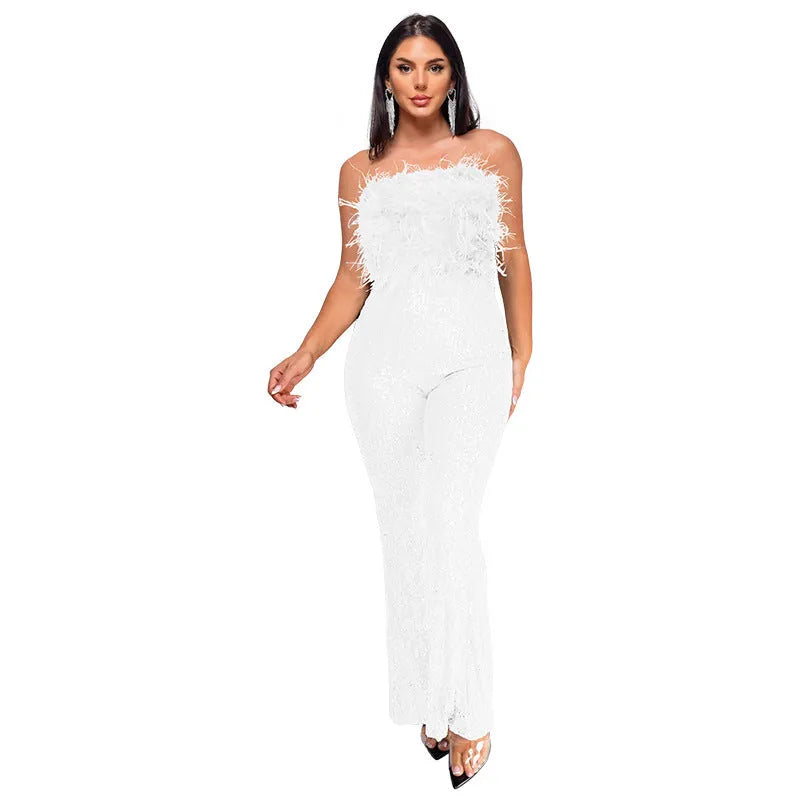 Women's black sleeveless backless jumpsuit with sequin detailing on top and flared legs.