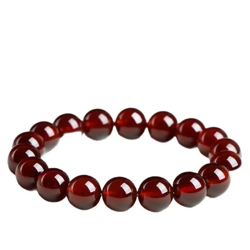 Natural orange red garnet ball bracelet with Ruyi elements on a wrist, showing retro unisex design.