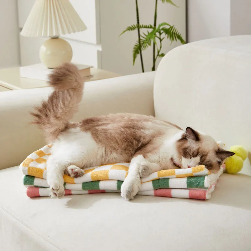 Plush pet blanket with plaid pattern and fur ball decoration for cats and dogs