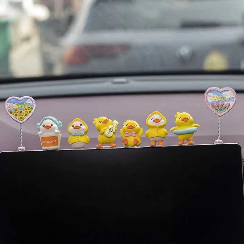 Set of six small yellow PVC duck figurines and one Hello sign for car dashboard decoration.
