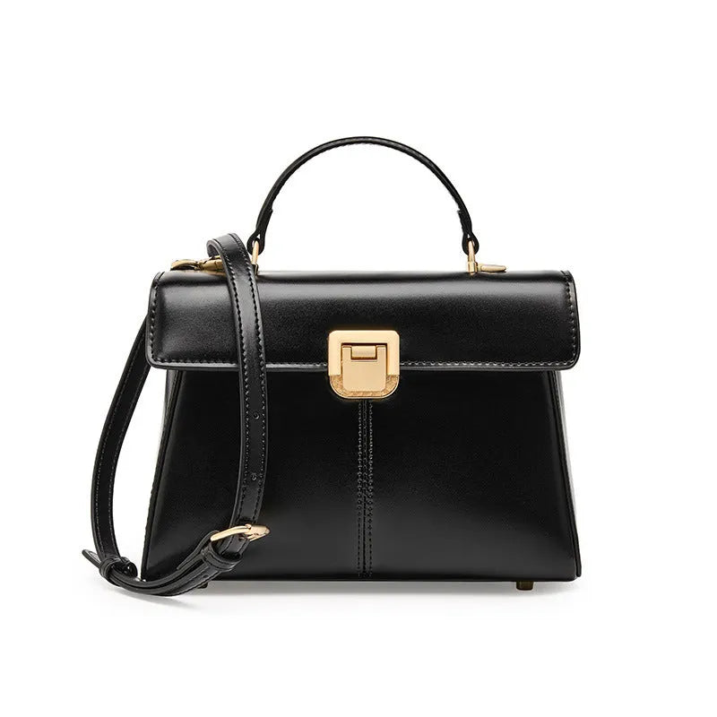 Black leather women's shoulder bag with vachette clasp showing square shape and adjustable strap.
