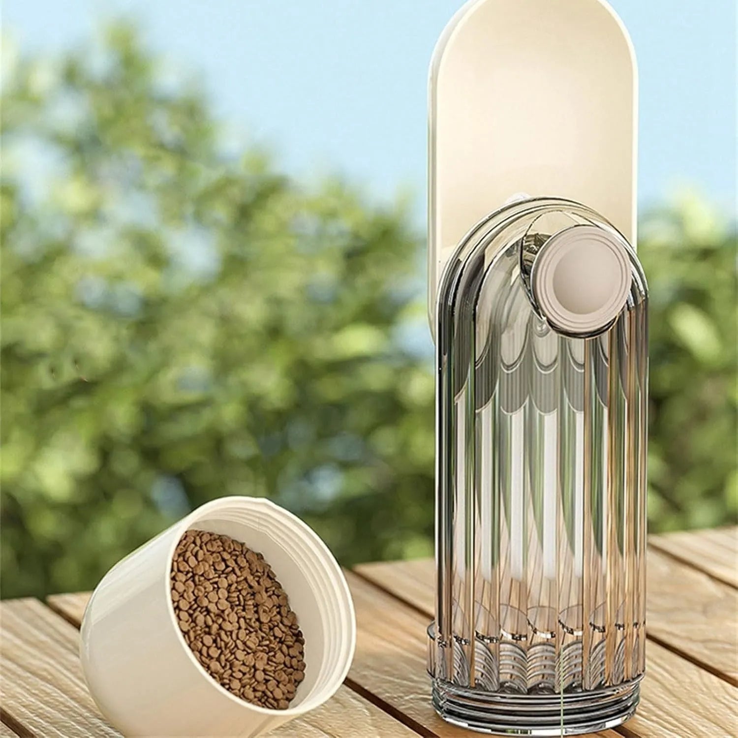 Beige foldable dog water bottle with food dispenser showing collapsible design and drinking tray