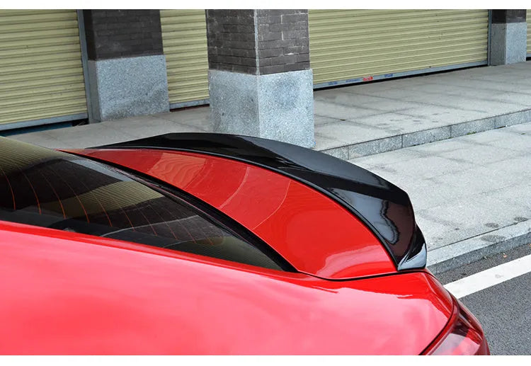 Large bright black tail blade spoiler for a Mazda 3 Axela car, showing wind-surrounded design.