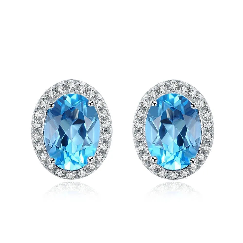 925 sterling silver jewellery set with blue topaz gems including geometric pendant necklace, earrings, ring, and bracelet.