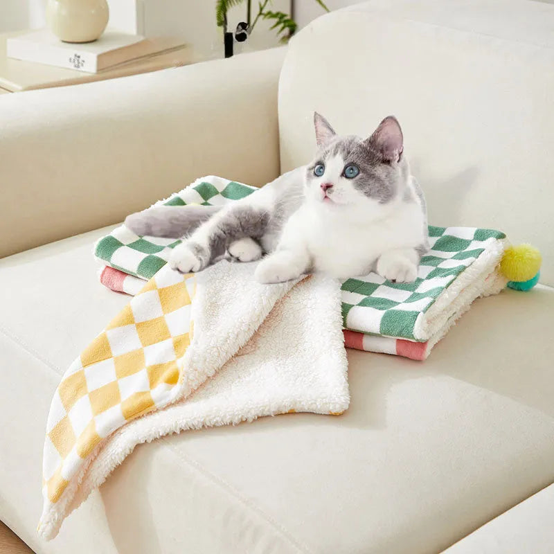 Plush pet blanket with plaid pattern and fur ball decoration for cats and dogs