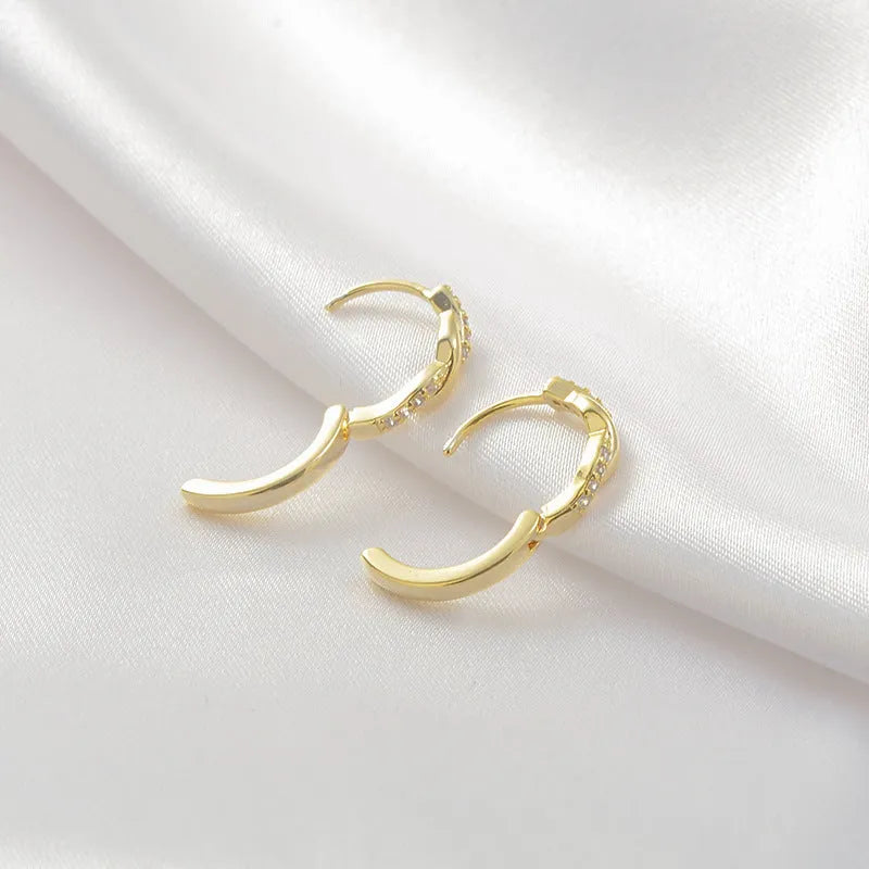 Women's geometric round earrings with interwoven hemp rope detail on a diamond-cut copper frame in gold colour.