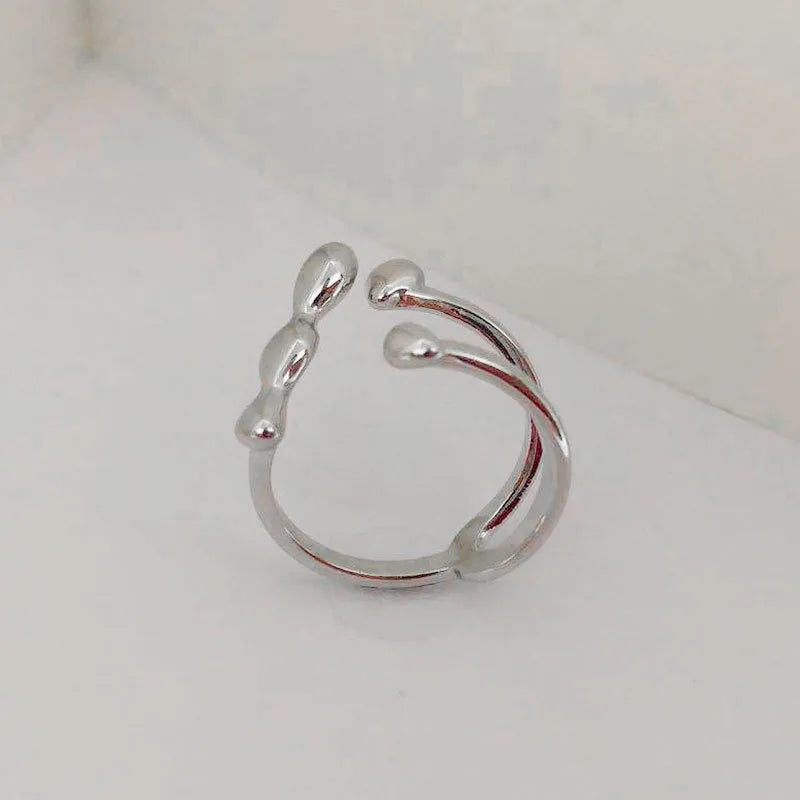 Brass opening ring with spherical element in gold finish on model finger