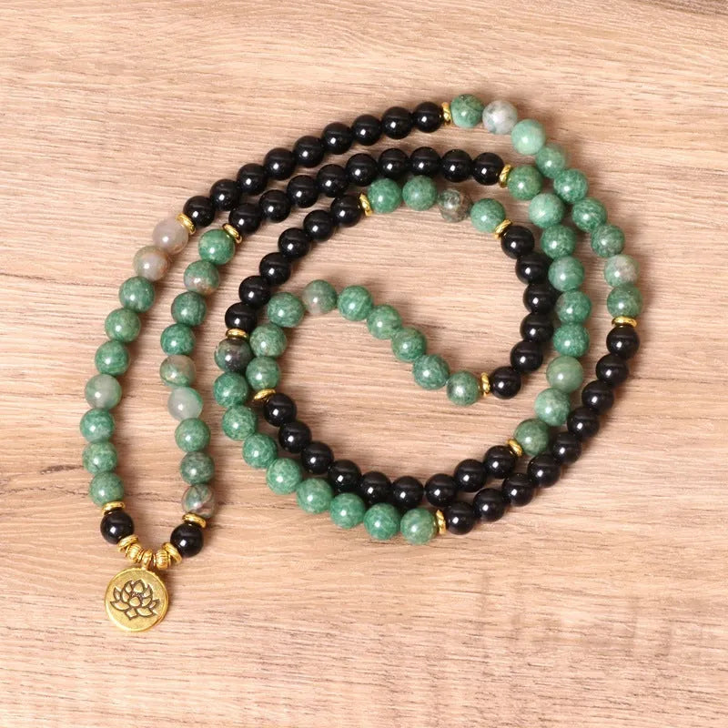 Green and black alloy elastic beaded bracelet with charm decorations on a stretch band.