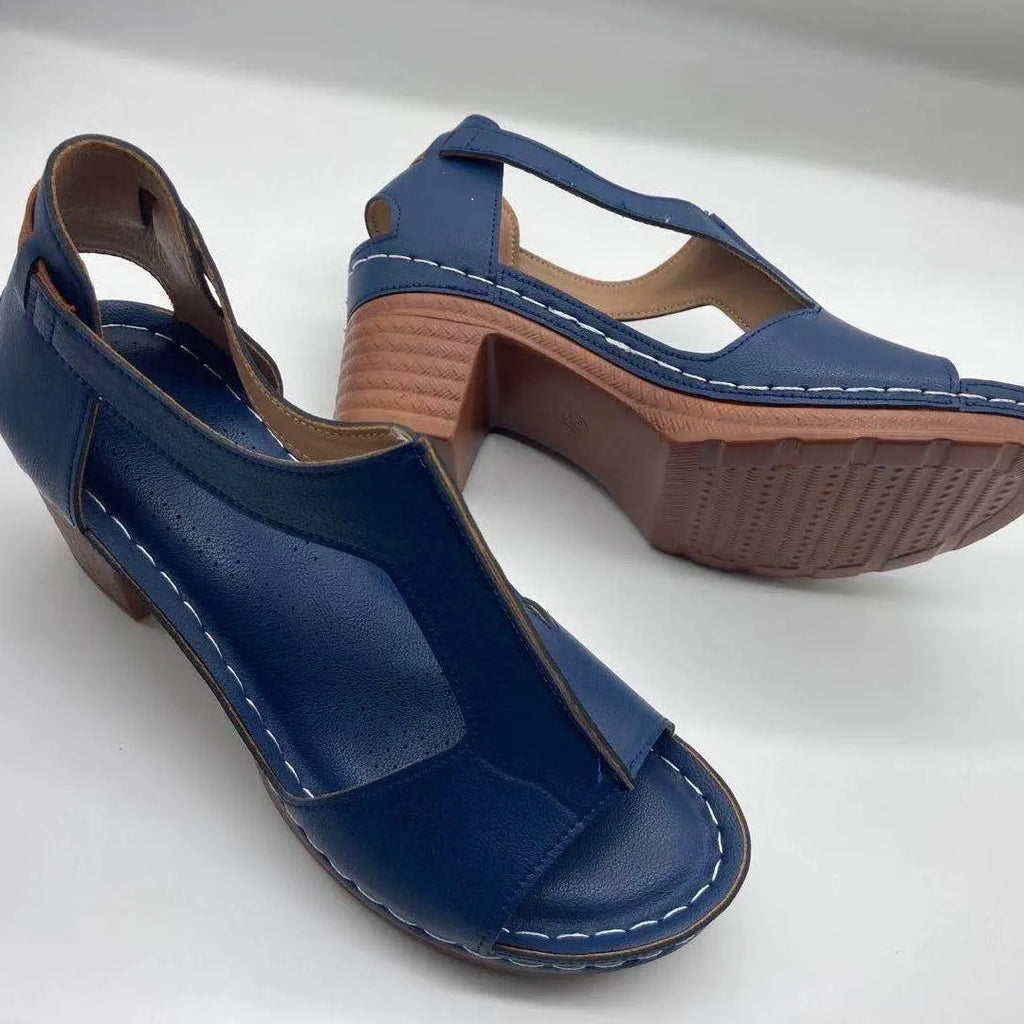 Women's white peep toe wedge sandals with a Roman-style buckle strap and low heel.