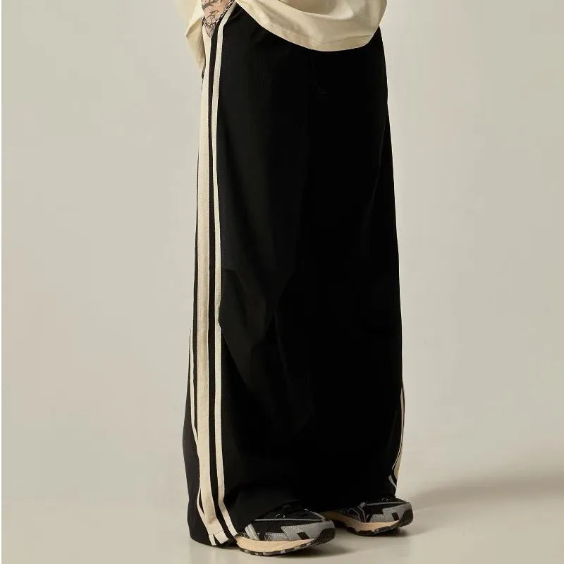 Black wide leg climbing trousers for men showing high waist and straight leg design on hanger.
