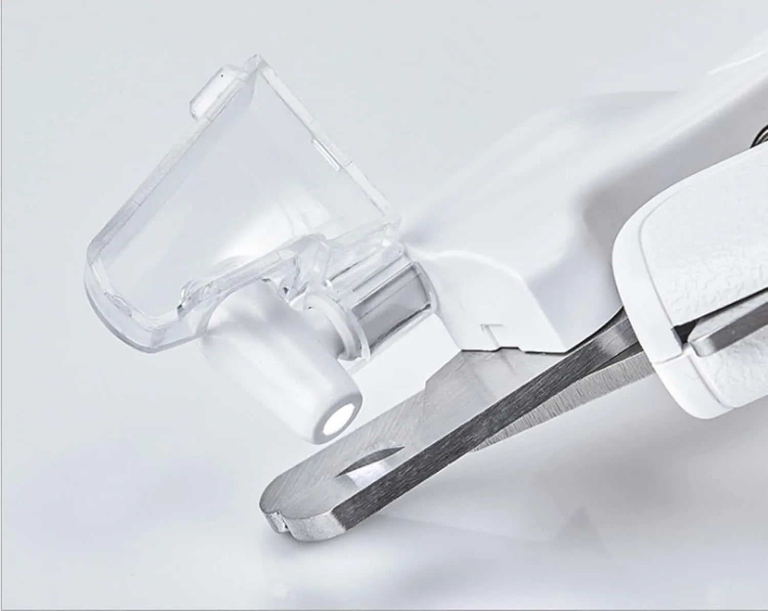 White pet nail clippers with LED light, transparent guard, and a separate nail file on a plain background.