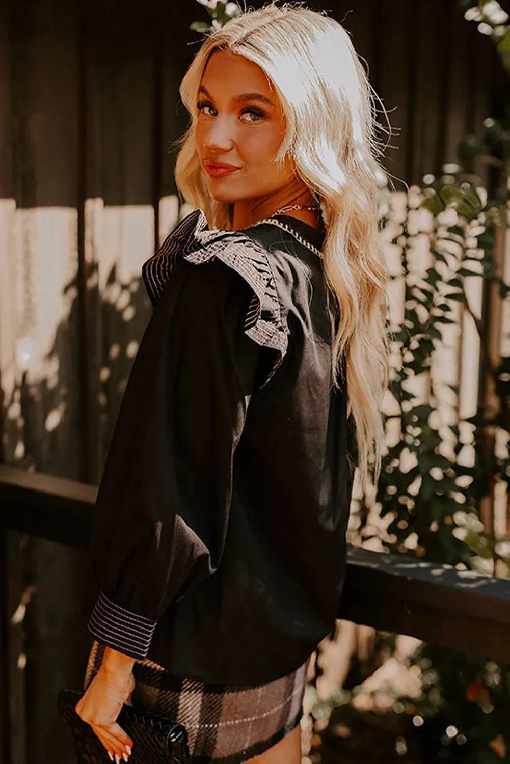 Black women's V-neck blouse with long ruffle sleeves and contrast stitching