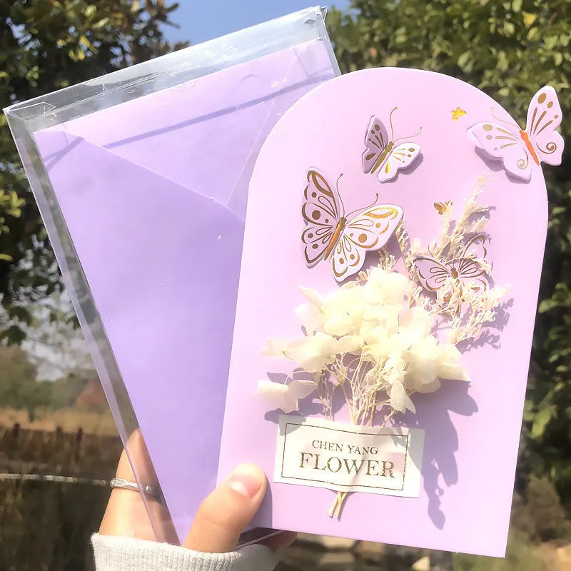 Handmade 3D boxed birthday card with butterfly shape and artificial flowers on coated paper.