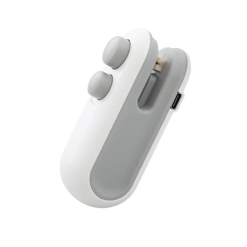 White handheld USB rechargeable heat sealer with cutter blade on a kitchen counter