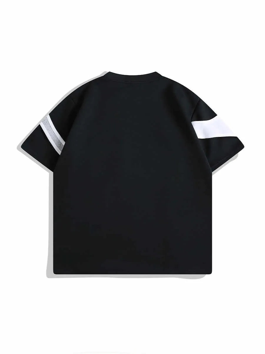 Man wearing a black loose-fit t-shirt with a padded strap detail on the shoulder.