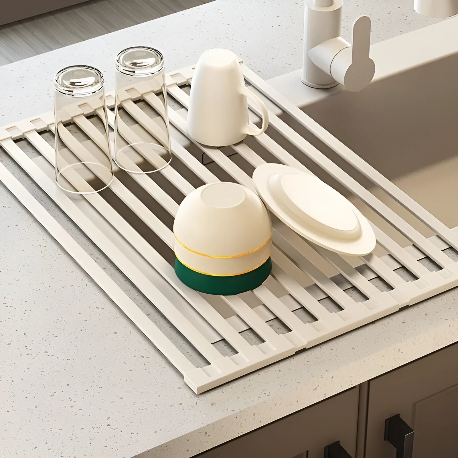 Milky white tri-fold stainless steel kitchen draining rack shown unfolded next to a sink.