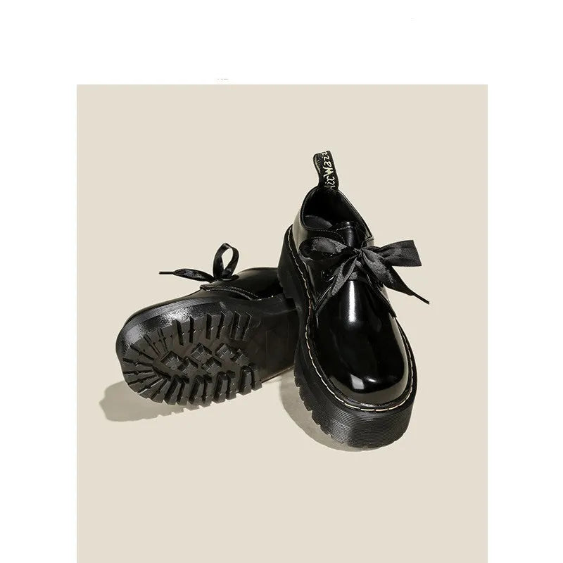 Women's white lace-up leather shoes with thick soles and black cross straps on the ankle.