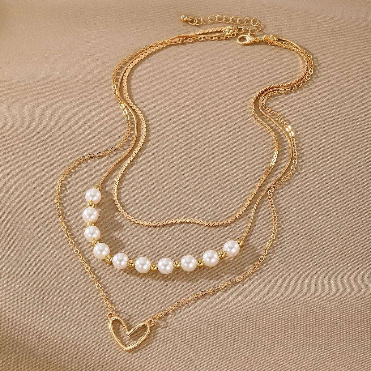 Vintage love heart pearl gold necklace with electroplated alloy pendant and adjustable pearl chain on a white background