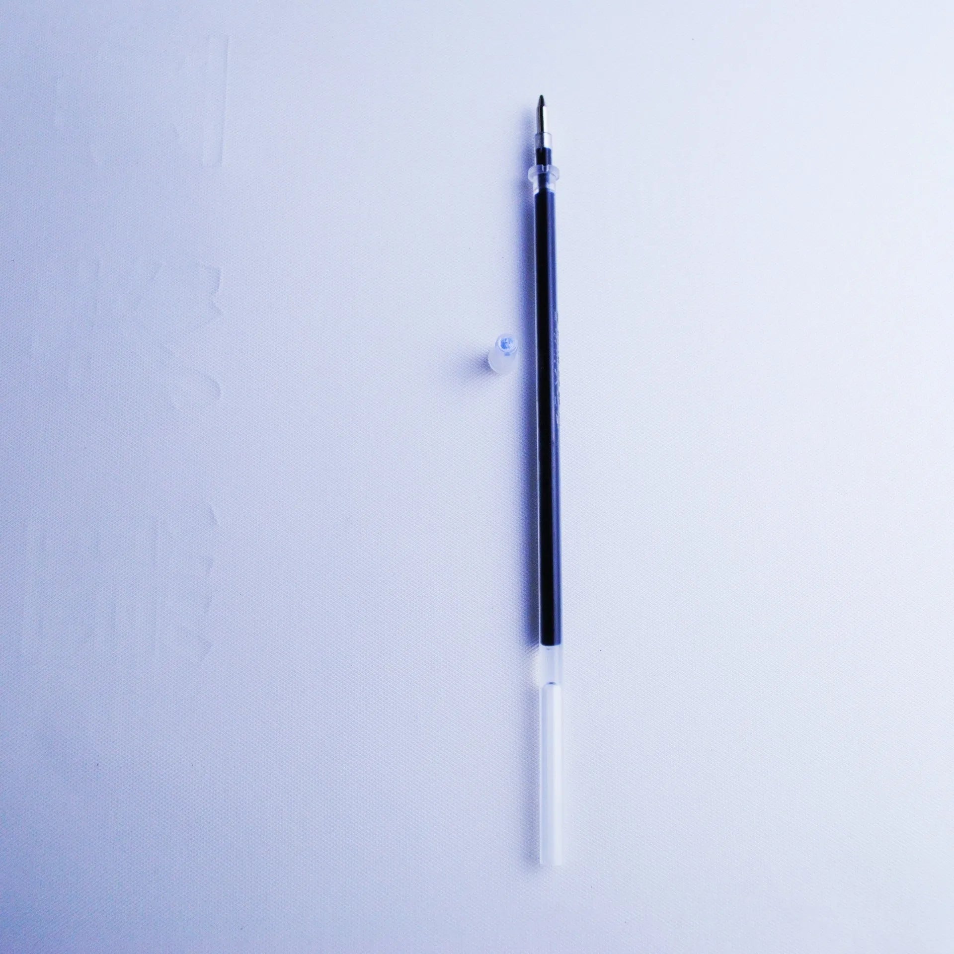 Blue automatic fading pen set with 0.5mm tip, eight refills, and plastic holder on white background