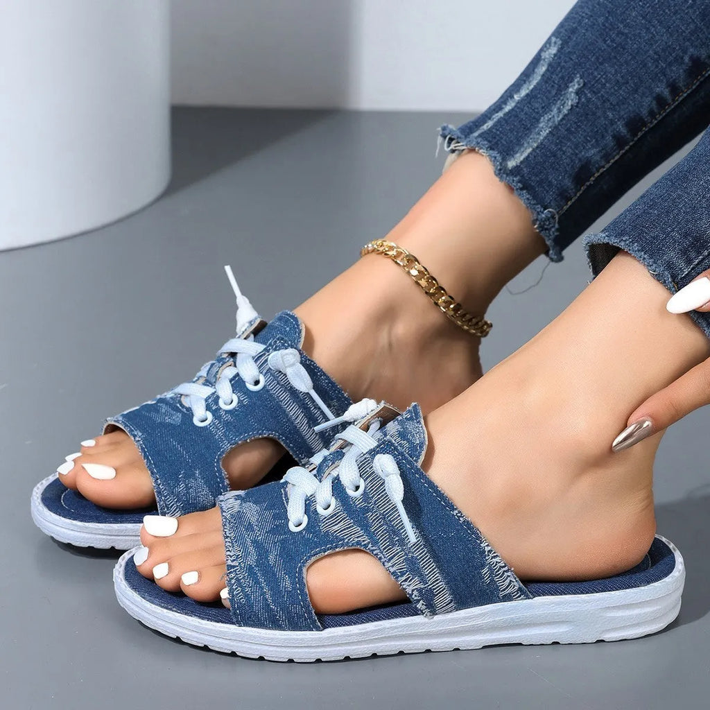 Blue women's Roman style canvas slippers with a flat rubber sole on a white background.