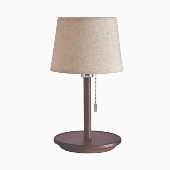 Walnut-coloured solid wood bedside lamp with white cloth shade and cable switch