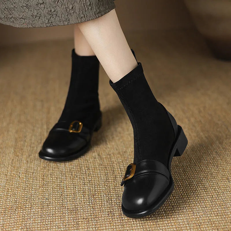 Black women's lace-up Martin boots with low heel and decorative belt buckle stitching on a white background.