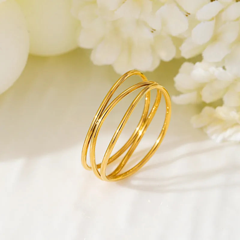 Gold titanium steel three-layer geometric line ring shown on finger, available in sizes No 5 to No 10