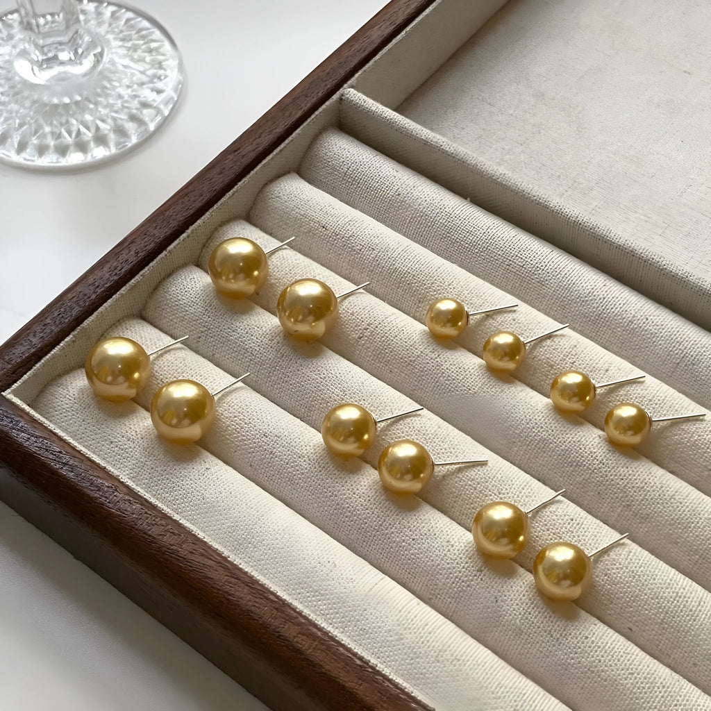 Large geometric pearl stud earrings with an Awn star setting in silver, shown in different size options.