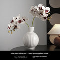White ceramic ball vase with stripes, American country style, shown on a table.