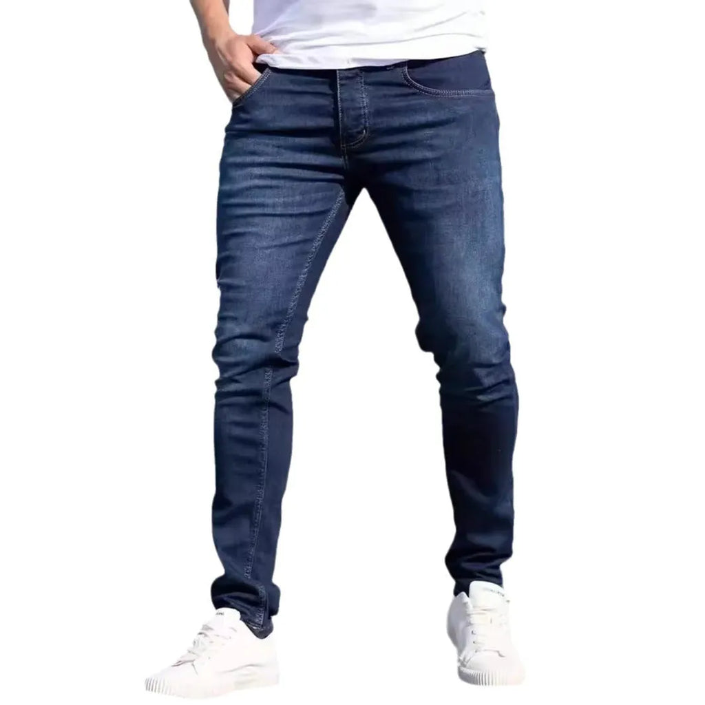Dark blue men's slim fit casual jeans with a tight leg style and mid waist design.