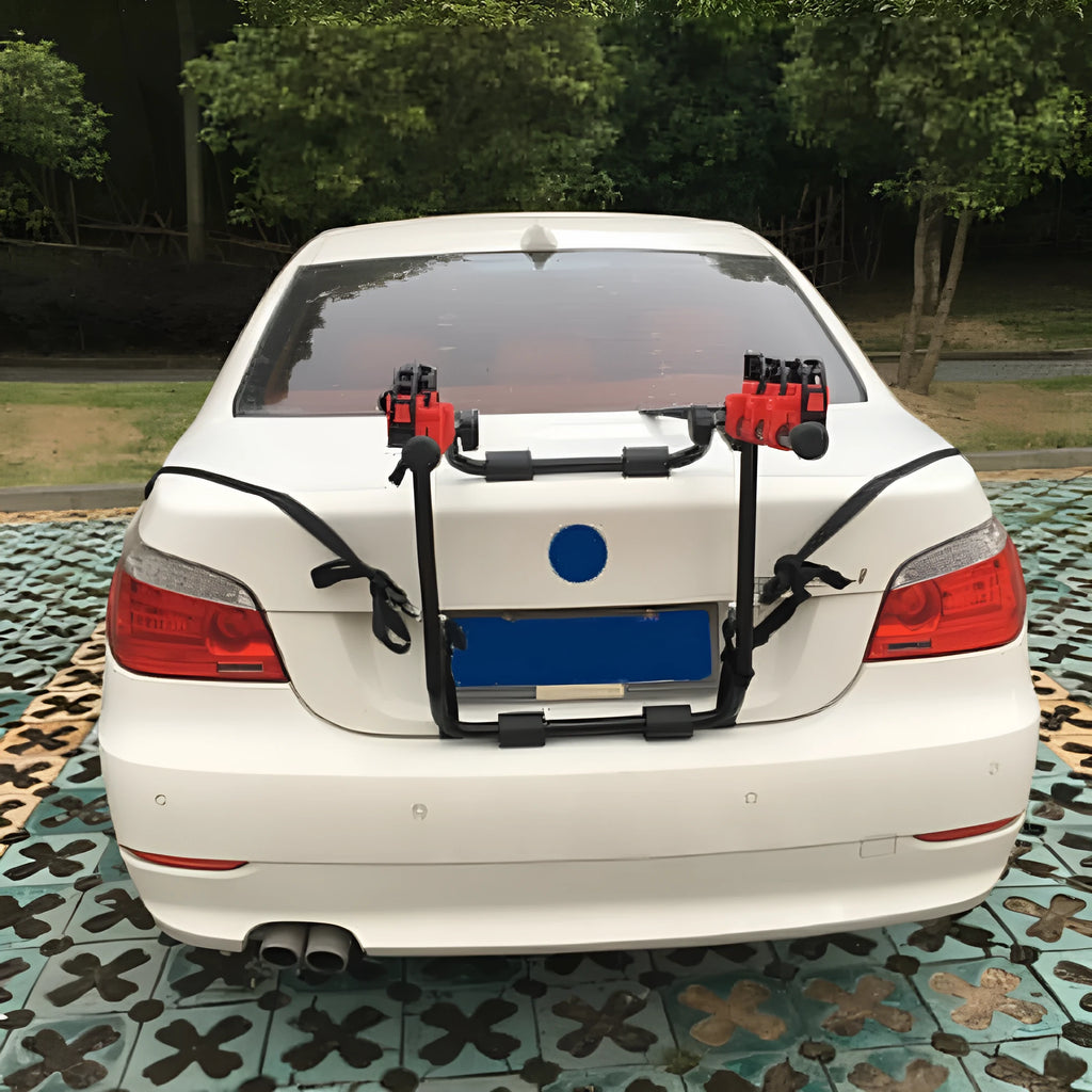 Black and red iron-framed car boot bike rack with tie rope fastenings.