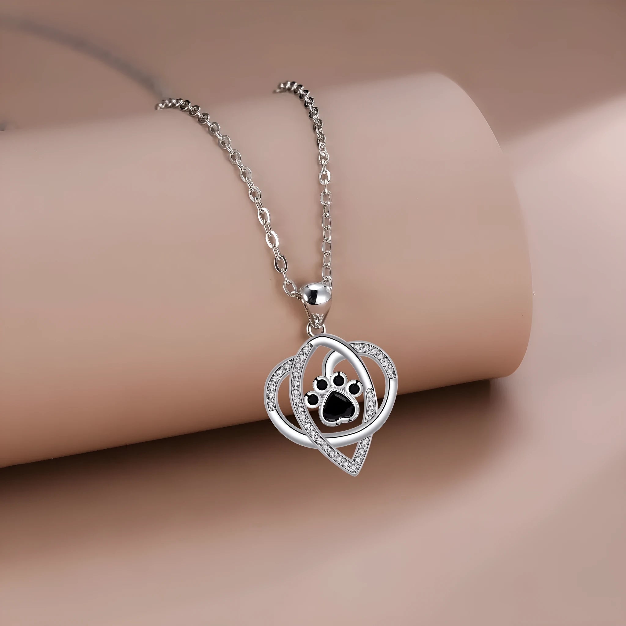 Copper necklace for women with a dog's paw print pendant on a cross chain.
