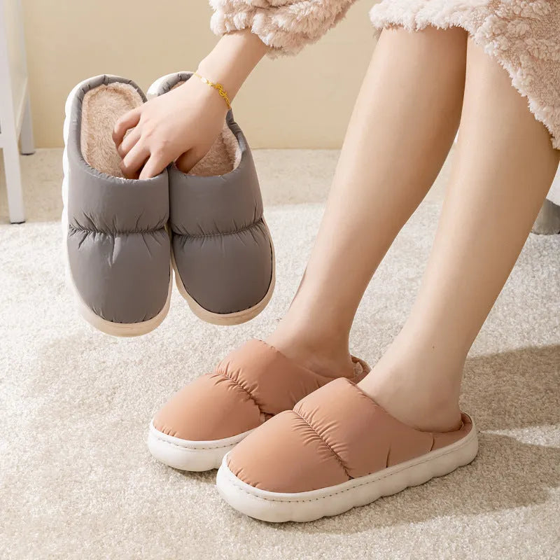 Blue winter house slippers with artificial leather upper, thick rubber sole, and plush lining on a wooden floor.