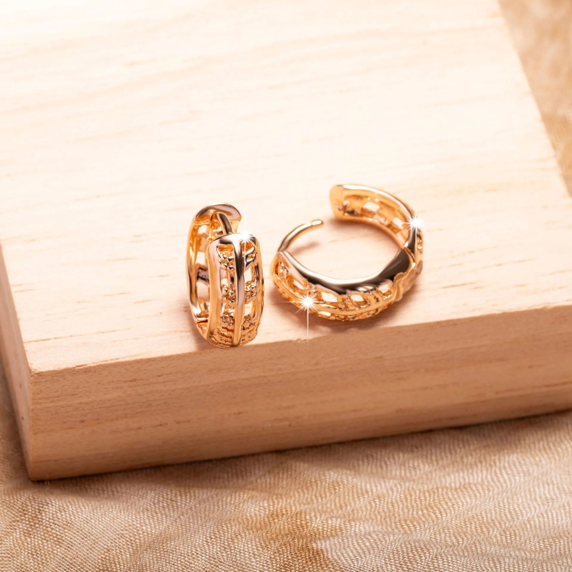 A pair of rose gold hollowed earrings with intricate leaf and heart shapes.