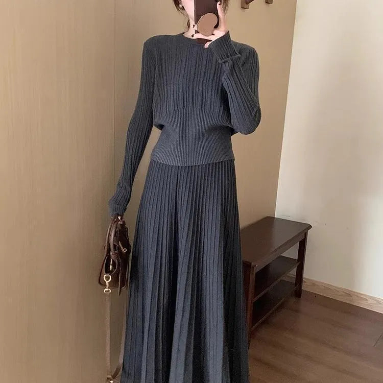 Women's dark grey knitted dress suit set with sweater and skirt showing 3D knit pattern and collage stitching