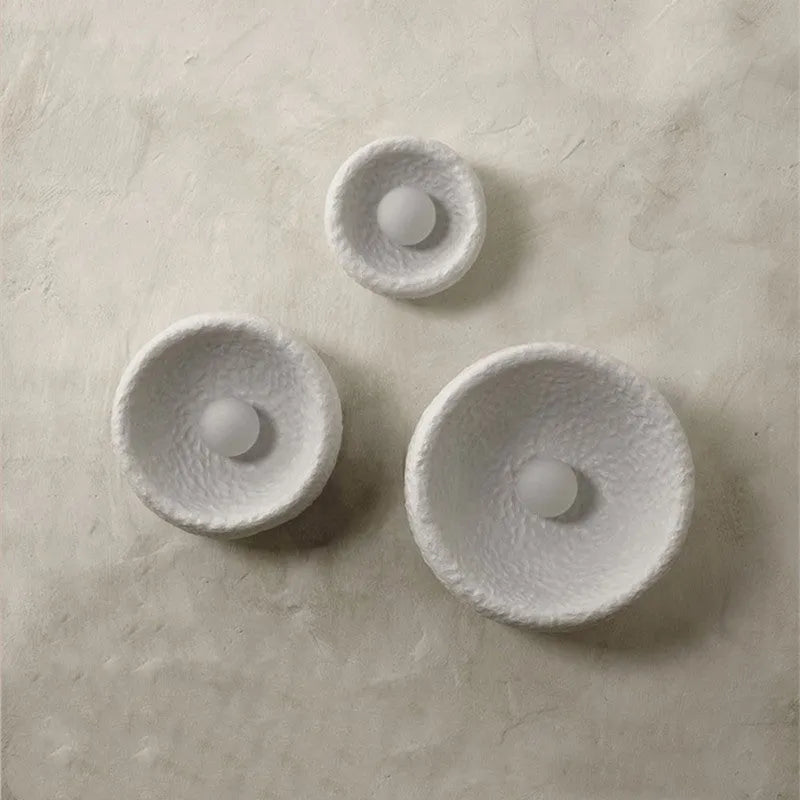 Japanese-style minimalist wall lamp with resin shade in three diameter sizes on white wall