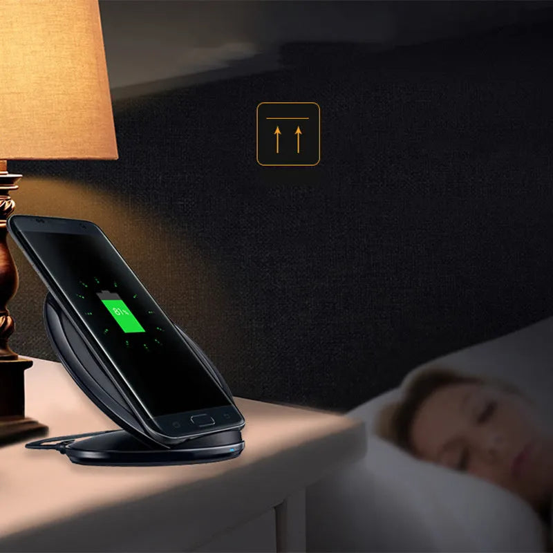 Black Qi wireless fast charging pad for Samsung Galaxy Note Edge on a desk next to a USB cable.