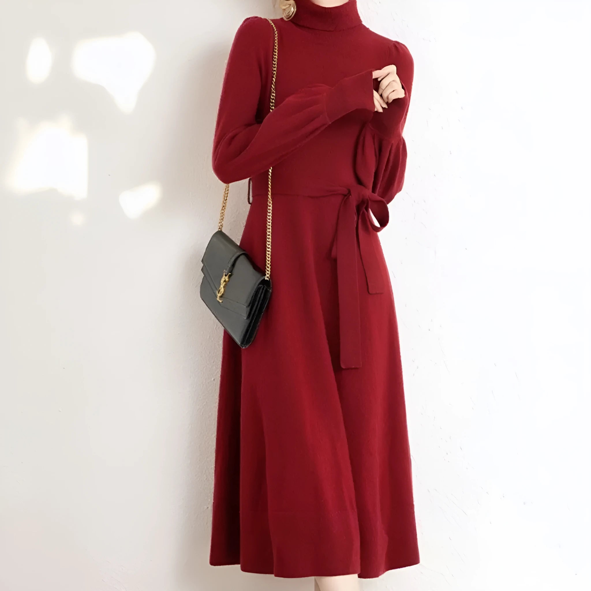 A woman wearing a rose red turtleneck long-sleeve knit dress with an elastic waist and loose hem.