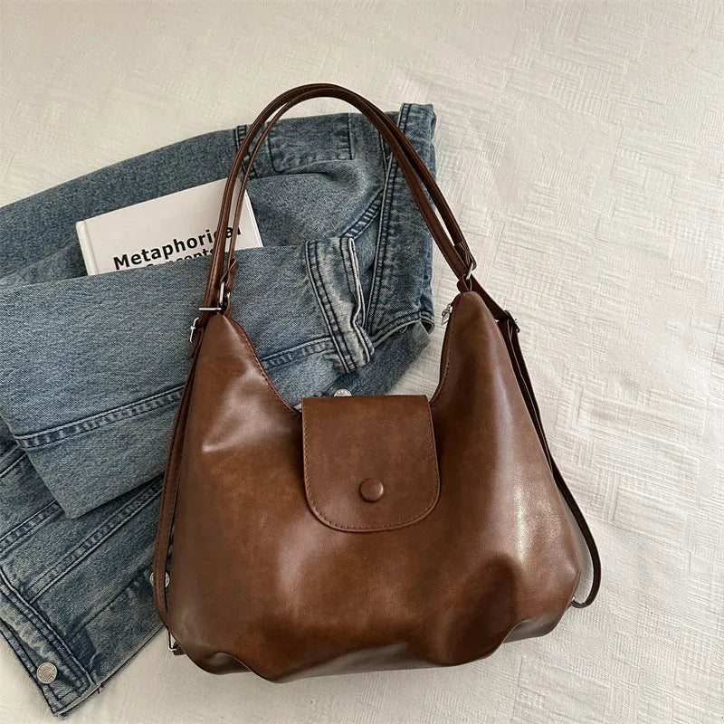 Black PU leather women's single strap shoulder bag showing horizontal square shape and internal mobile phone compartment