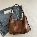 Black PU leather women's single strap shoulder bag showing horizontal square shape and internal mobile phone compartment