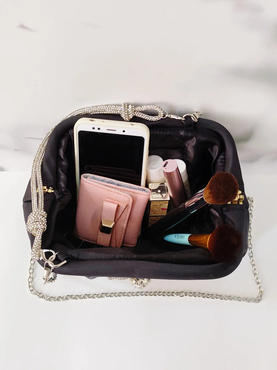 Women's black shell shape crossbody bag with diamond pattern and chain details showing internal document compartment