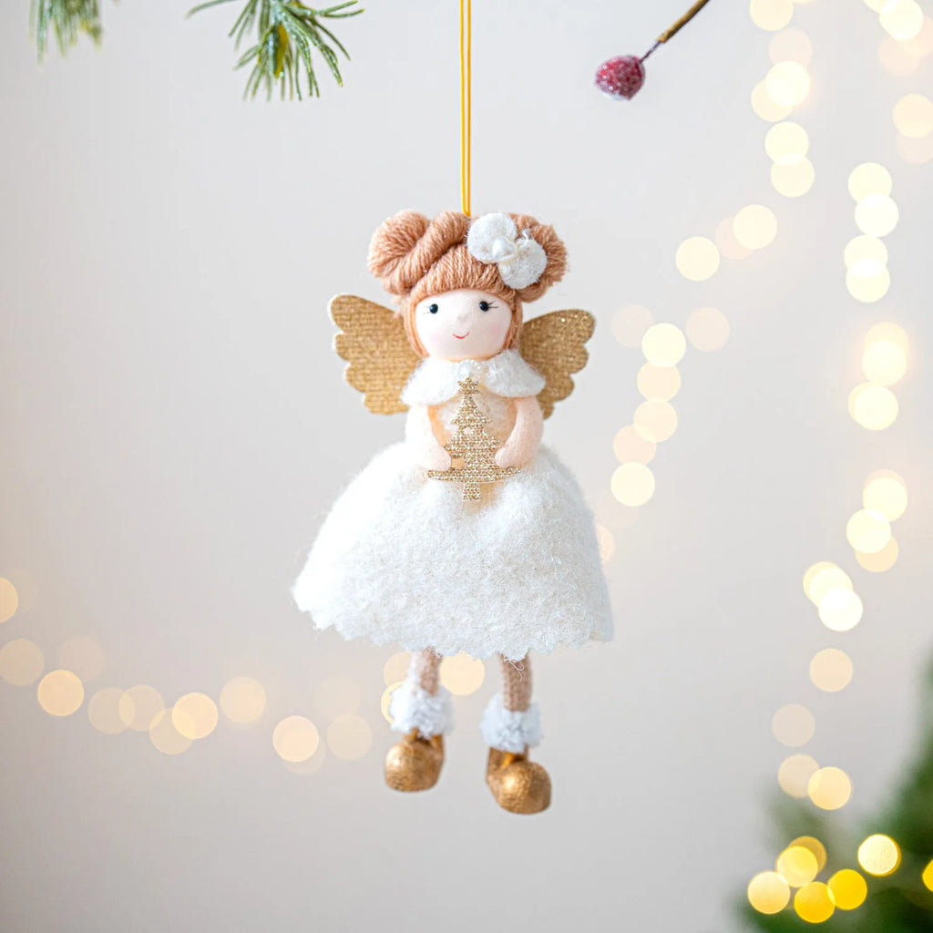Soft pink cloth Christmas pendant ornament shaped like angel wings on a green branch.