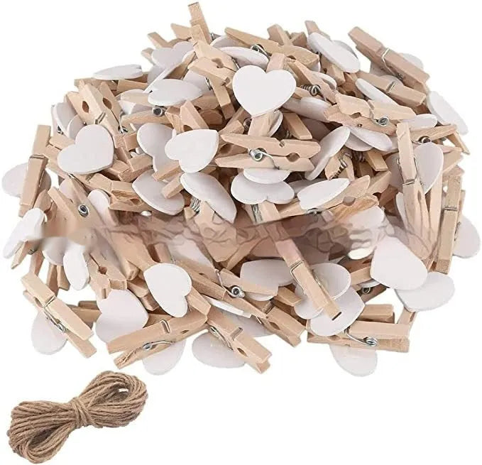 Five handmade solid wood heart-shaped clips in red, pink, white, yellow colours on a wood surface.