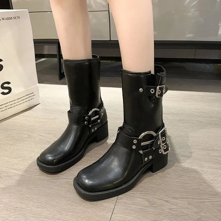 Women's black platform boots with belt buckle decoration showing mid-calf height