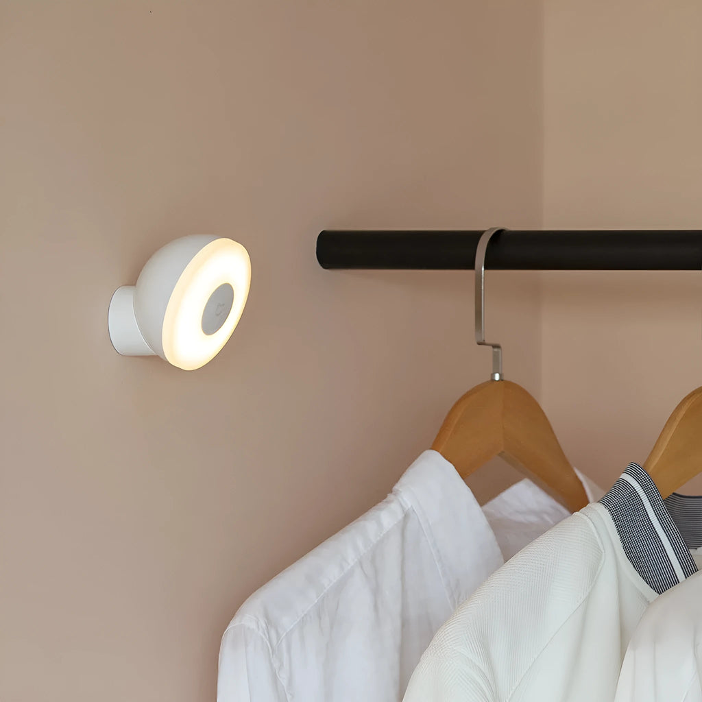 White modern bedside table lamp with human body induction and Bluetooth on a wooden nightstand.